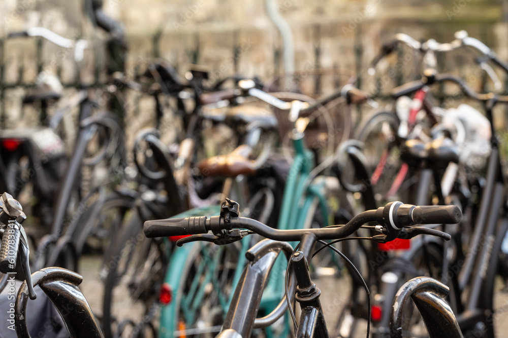 Selective blur on the handlebar of bicycles, parked in a bicycle parking, in Maastricht city center. Cycling and bikes are a symbol of netherlands. Selective blur on the handlebar of bicycles, parked in a bicycle parking, in Maastricht city center. Cycling and bikes are a symbol of netherlands.