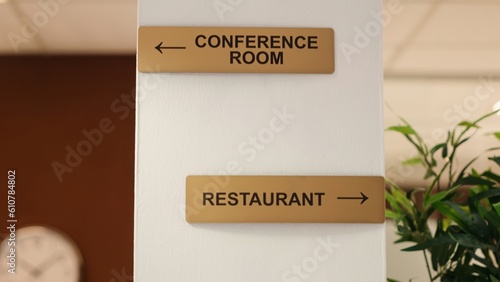 Close up of hotel facilities plaques on hotel lounge wall and folders of tourist accommodation paperwork in reception. Directions to conference room, spa center and restaurant resort amenities photo