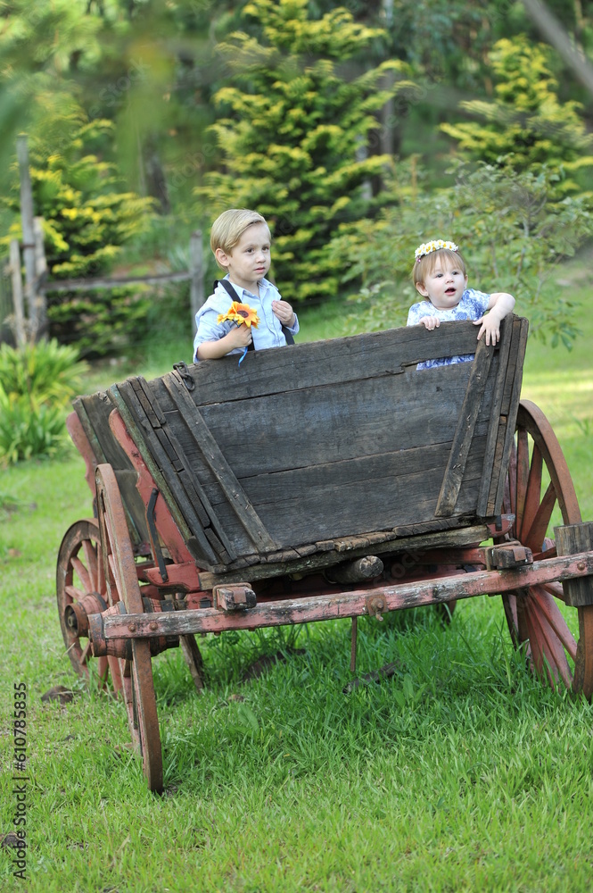 Foto de crianças brincando em carroça na fazenda do Stock | Adobe Stock