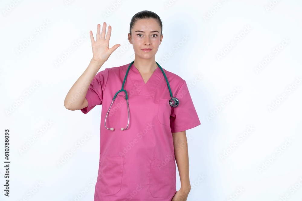young caucasian doctor woman wearing pink uniform over white background showing and pointing up with fingers number five while smiling confident and happy. young caucasian doctor woman wearing pink uniform over white background showing and pointing up with fingers number five while smiling confident and happy.