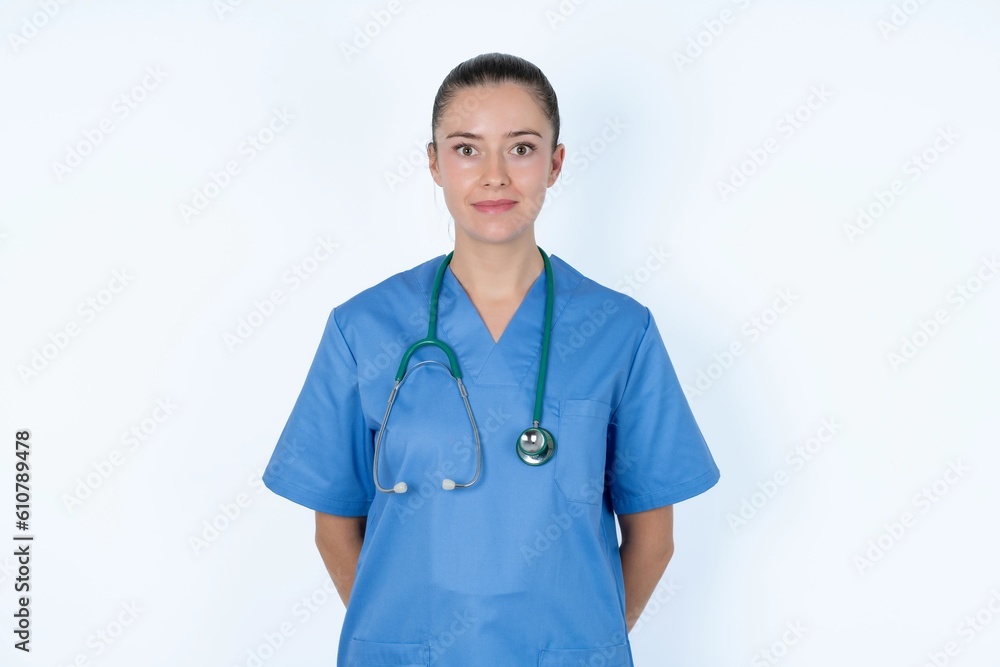 Stunned young caucasian doctor woman wearing medical uniform over white background stares reacts on shocking news. Astonished woman holds breath Stunned young caucasian doctor woman wearing medical uniform over white background stares reacts on shocking news. Astonished woman holds breath