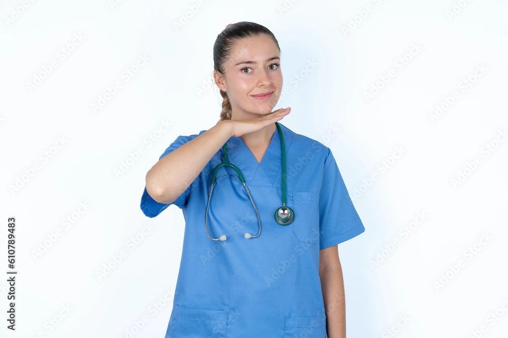 young caucasian doctor woman wearing medical uniform over white background cutting throat with hand as knife, threaten aggression with furious violence. young caucasian doctor woman wearing medical uniform over white background cutting throat with hand as knife, threaten aggression with furious violence.