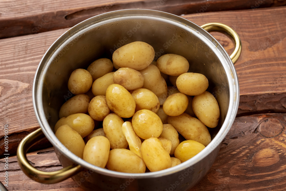 Boiled young small potatoes in a saucepan on a wooden background. Boiled young small potatoes in a saucepan on a wooden background.