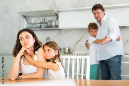 Upset family with son and daughter arguing in kitchen at home
