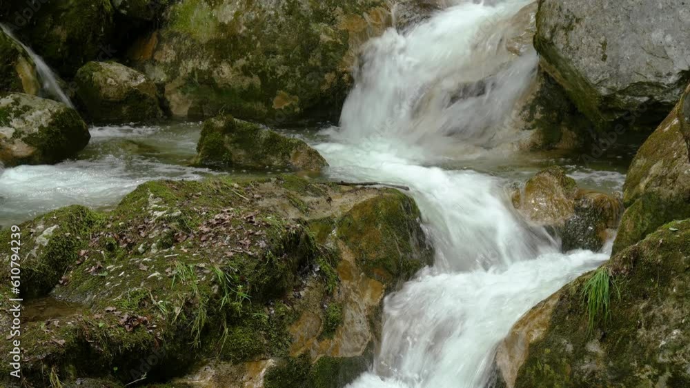 Mountain cascade flows between huge mossy rocks Mountain cascade flows between huge mossy rocks