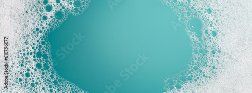 Detergent foam bubble on water. Blue background, Soap sud photo