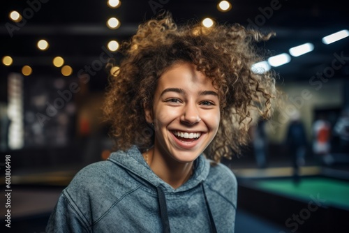 Close-up portrait photography of a pleased woman in her 30s that is wearing a denim jacket against a high-energy indoor trampoline park with jumpers background .  Generative AI © Eber Braun