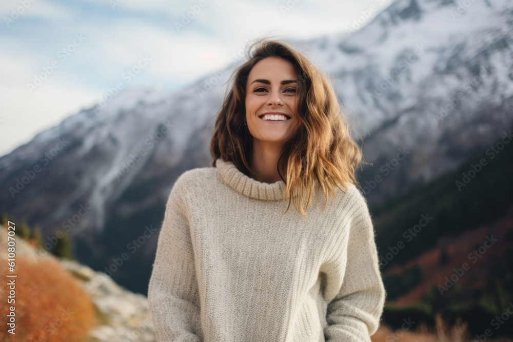 Portrait of a beautiful smiling young woman in sweater on the background of the mountains Portrait of a beautiful smiling young woman in sweater on the background of the mountains