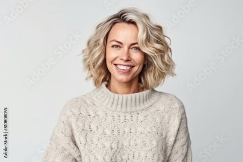 Portrait of a smiling woman in sweater looking at camera isolated over white background