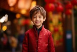Portrait of a cute little boy in a red coat looking at the camera