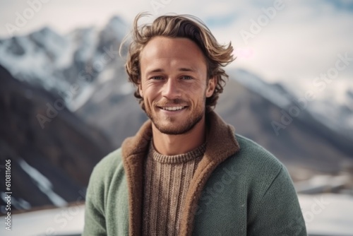 Medium shot portrait photography of a pleased man in his 20s that is wearing a chic cardigan against a snowy mountain peak or summit background .  Generative AI © Leon Waltz