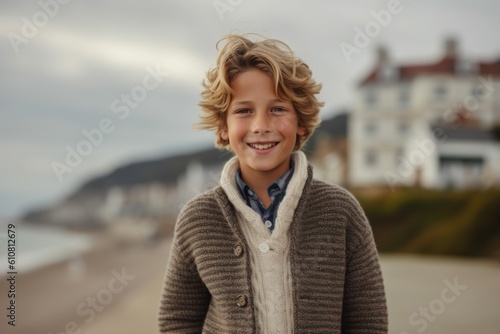Portrait of a smiling young boy standing on the beach by the sea