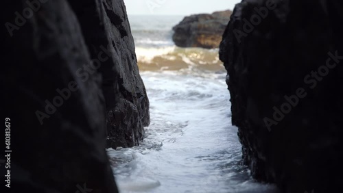 Atmospheric video in the middle of the rock to which the waves are nailed.