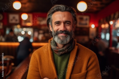 Portrait of mature man standing in cafe, looking at camera.