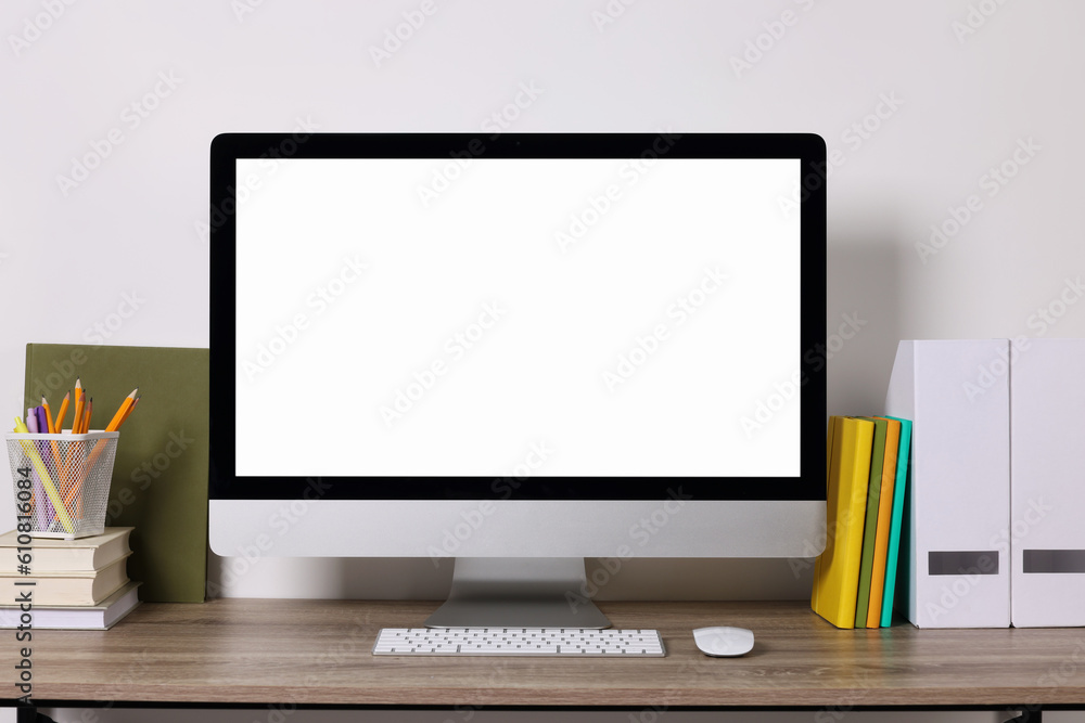Cozy workspace with modern computer and stationery on wooden desk Cozy workspace with modern computer and stationery on wooden desk