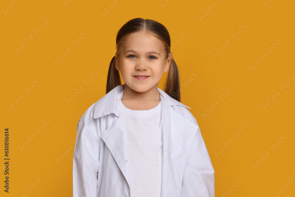Portrait of little girl in medical uniform on yellow background Portrait of little girl in medical uniform on yellow background
