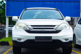 front view of white suv or crossover car in showroom car park with rusty chain barrier