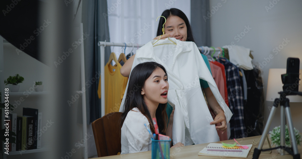 Young Beautiful Asian women live streaming at clothes shop on smartphone Young Beautiful Asian women live streaming at clothes shop on smartphone