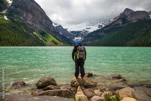 Panorama of Lake Louise, Banff National Park, Alberta, Canada. Lifestyle Travel - Backpack hiker standing by Lake and looks on amazing landscape. Active life.