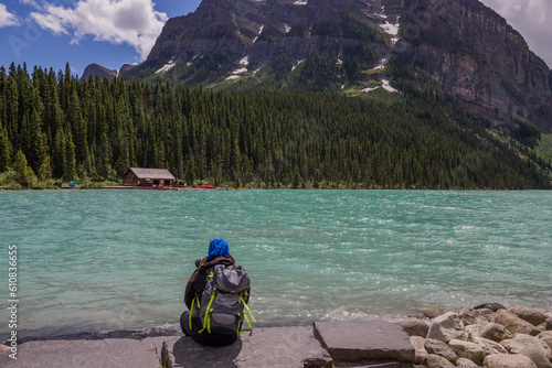 Panorama of Lake Louise, Banff National Park, Alberta, Canada. Lifestyle Travel - Backpack hiker sitting by Lake, relax and looks on amazing landscape. Active life. 