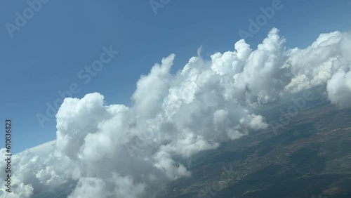 Unique pilot’s perspective while flying trough a sky with some fluffy tiny clouds during a right turn. Daylight. 6000m high. photo