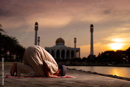 A little Asian Muslim boy is praying with peace in the beautiful mosque, giving a powerful atmosphere of faith, with copy space, islam concept.