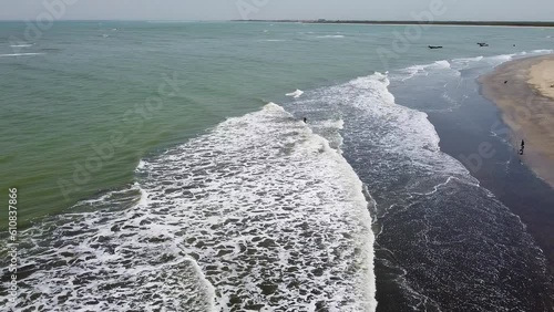 Bakau, The Gambia panning right over the sea beach with tourists swimming in the ocean photo