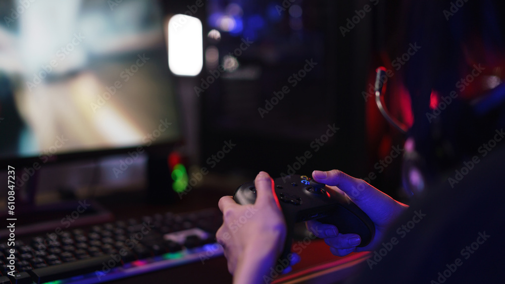 Hand of female cyber hacker gamer holding controller joystick to playing games on computer Hand of female cyber hacker gamer holding controller joystick to playing games on computer