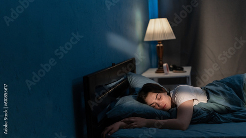 Obraz na plátně Young woman sleeping in soft bed in late at night