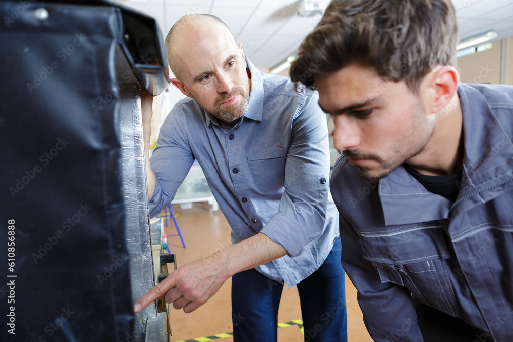 3d printer with two men looking at monitor screen 3d printer with two men looking at monitor screen