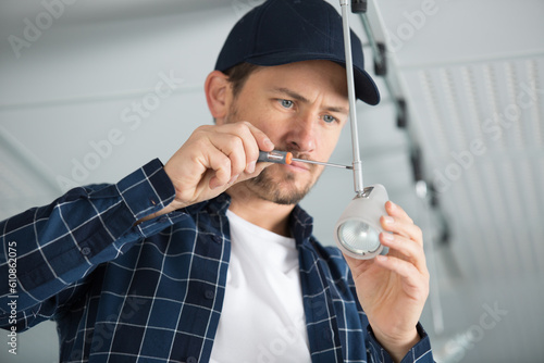 male worker screws a light photo