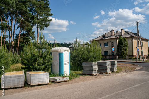 Portable toilet and building materials on the street