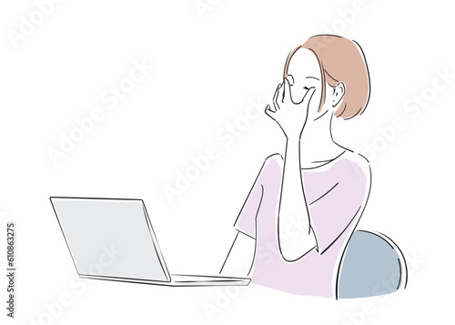 ノートパソコンでの作業で目が疲れて休む女性