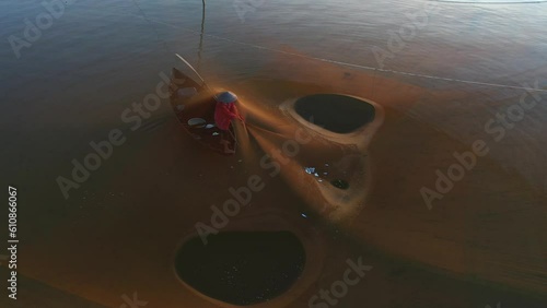 Fishermen throwing fishing net during dawn with boats at the sea gate. Concept Fisherman's life style. Cua Dai, Hoi An, Asia, Vietnam.