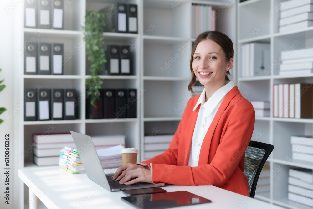 Charming businesswoman sitting working on laptop computer in office. Smiling female employee executive typing message using laptop computer for business in modern office. Charming businesswoman sitting working on laptop computer in office. Smiling female employee executive typing message using laptop computer for business in modern office.
