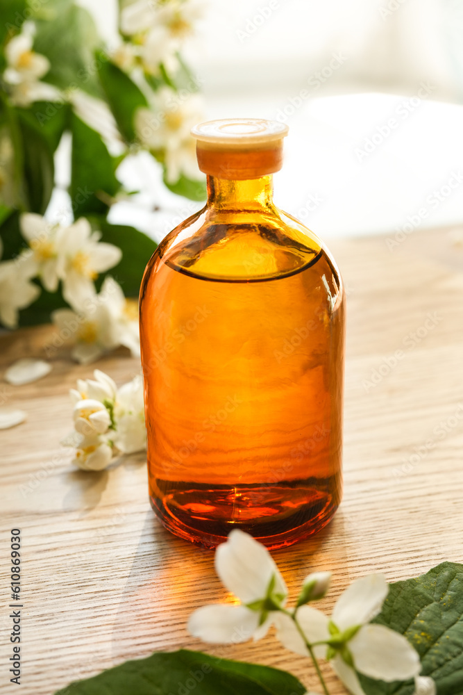 Small glass bottle of jasmine tincture(water infusion, extract, perfume). Jasmine essential oil. Fragrant flower for perfumery, cosmetics production. Side view, copy space for text, product place. Small glass bottle of jasmine tincture(water infusion, extract, perfume). Jasmine essential oil. Fragrant flower for perfumery, cosmetics production. Side view, copy space for text, product place.