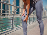 City Running - asian woman runner , Dubai marina urban scene in background. Female athlete, fitness athlete jogging training, living healthy lifestyle.