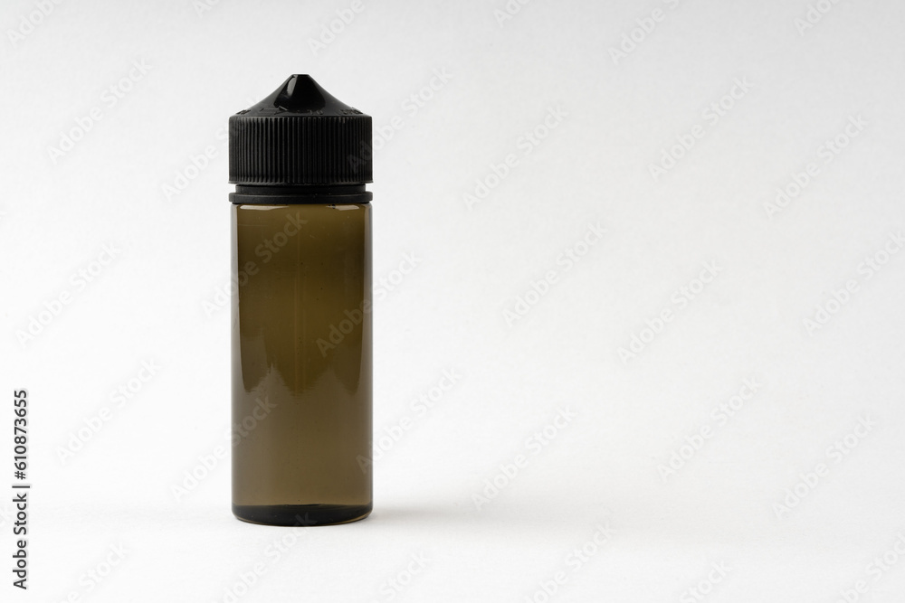 Small black glass dropper bottle front view on gray background Small black glass dropper bottle front view on gray background