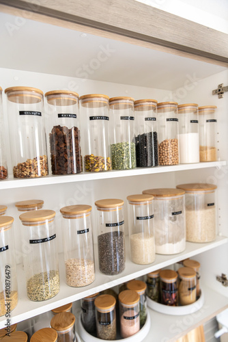 Tableau sur toile Neatly organized labeled food pantry in a home kitchen with spices grains flour