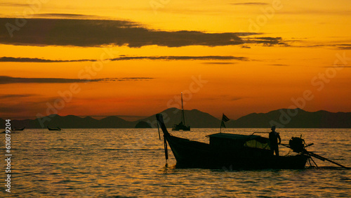 Sunset in the sea with a boat, in Ao Nang, Thailand.