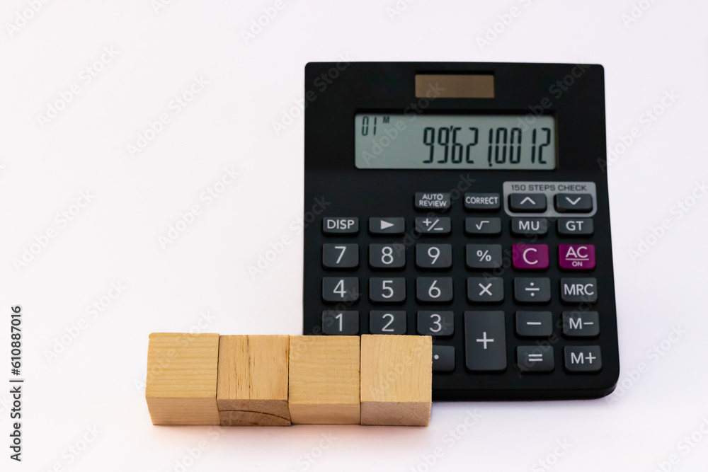 Four wooden blocks placed horizontally on the base of a calculator for saving concept. Four wooden blocks placed horizontally on the base of a calculator for saving concept.