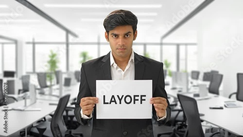 Angry Indian manager holding LAYOFF banner