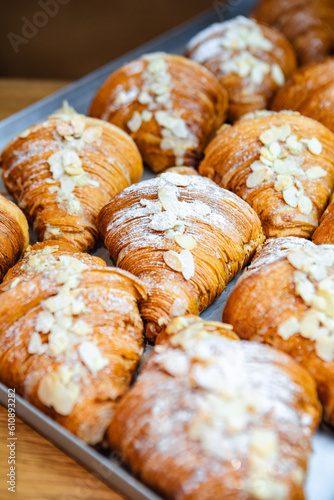 Sprinkle the finished croissants on a baking sheet with almond flakes and powdered sugar