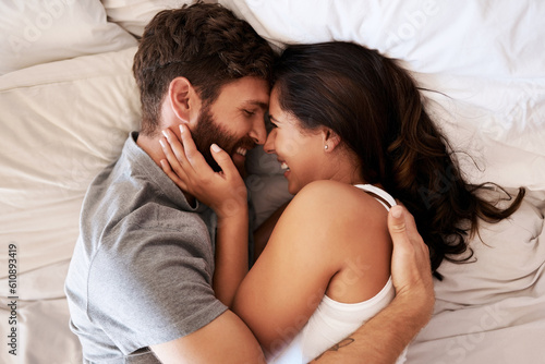 Smile, bed and happy couple hug, relax and spending lazy morning together, bonding and intimacy on Spain vacation. Happiness, marriage and top view of romantic man, woman or people embrace in bedroom