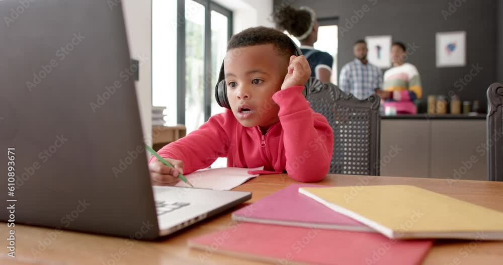 African american boy using headphones and laptop raising hand in online lesson, slow motion African american boy using headphones and laptop raising hand in online lesson, slow motion