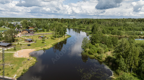 panoramic view of the river and coastal forest and houses on a summer day shot from a drone