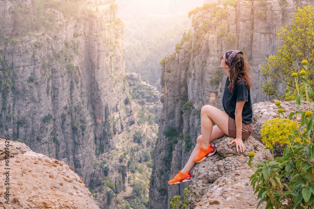 Obraz premium Happy traveler girl sitting on top of the Tazi canyon in Turkey. Tourist attractions and destinations