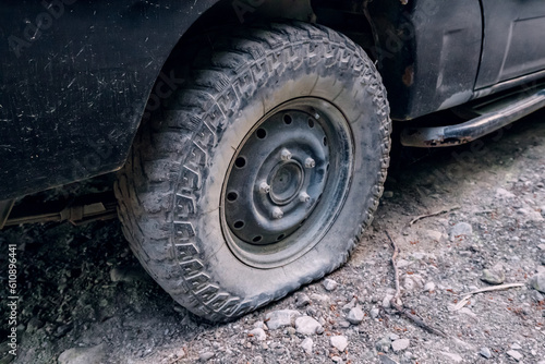 SUV flat tire on the side of a dirt road