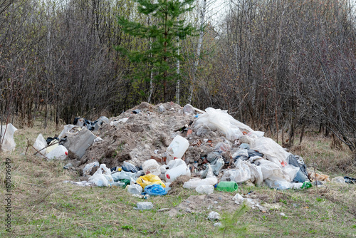 a large pile of garbage on the background of the forest. Environmental problems with plastic and garbage in the forest