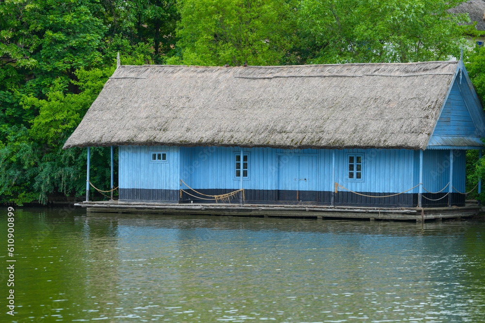 the old wooden house with a reed roof at the edge of the lake. the old wooden house with a reed roof at the edge of the lake.